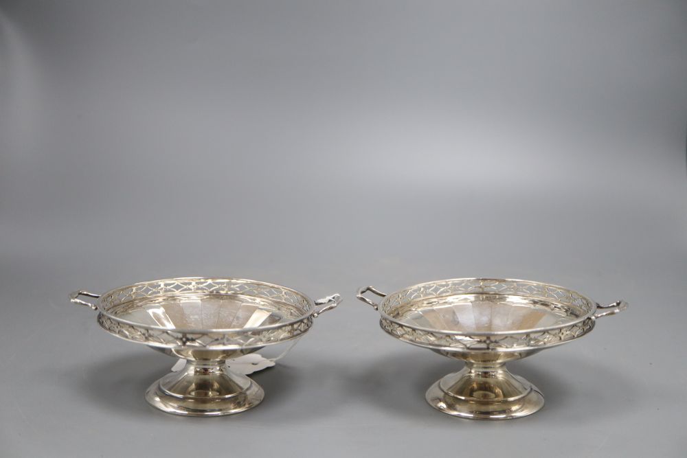 A pair of silver two handled bon bon dishes, with pierced gallery on circular bases, Birmingham 1925, 5.1oz. gross, width 11cm